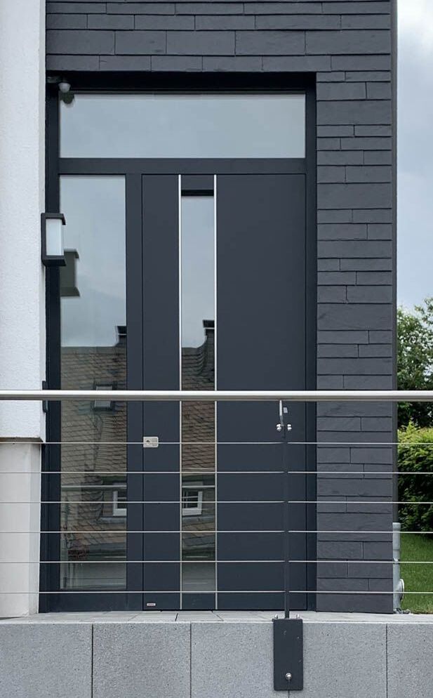 Das Bild zeigt eine moderne Stahl-Haustür in Arnsberg mit hohem Glaseinsatz. Die Haustür wurde in Brilon bei Kruse Türen und Böden gekauft.